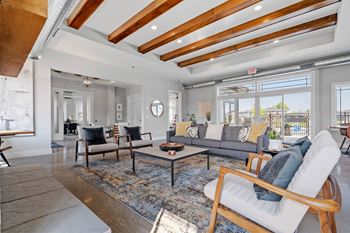 a living room with a couch and chairs and a large window